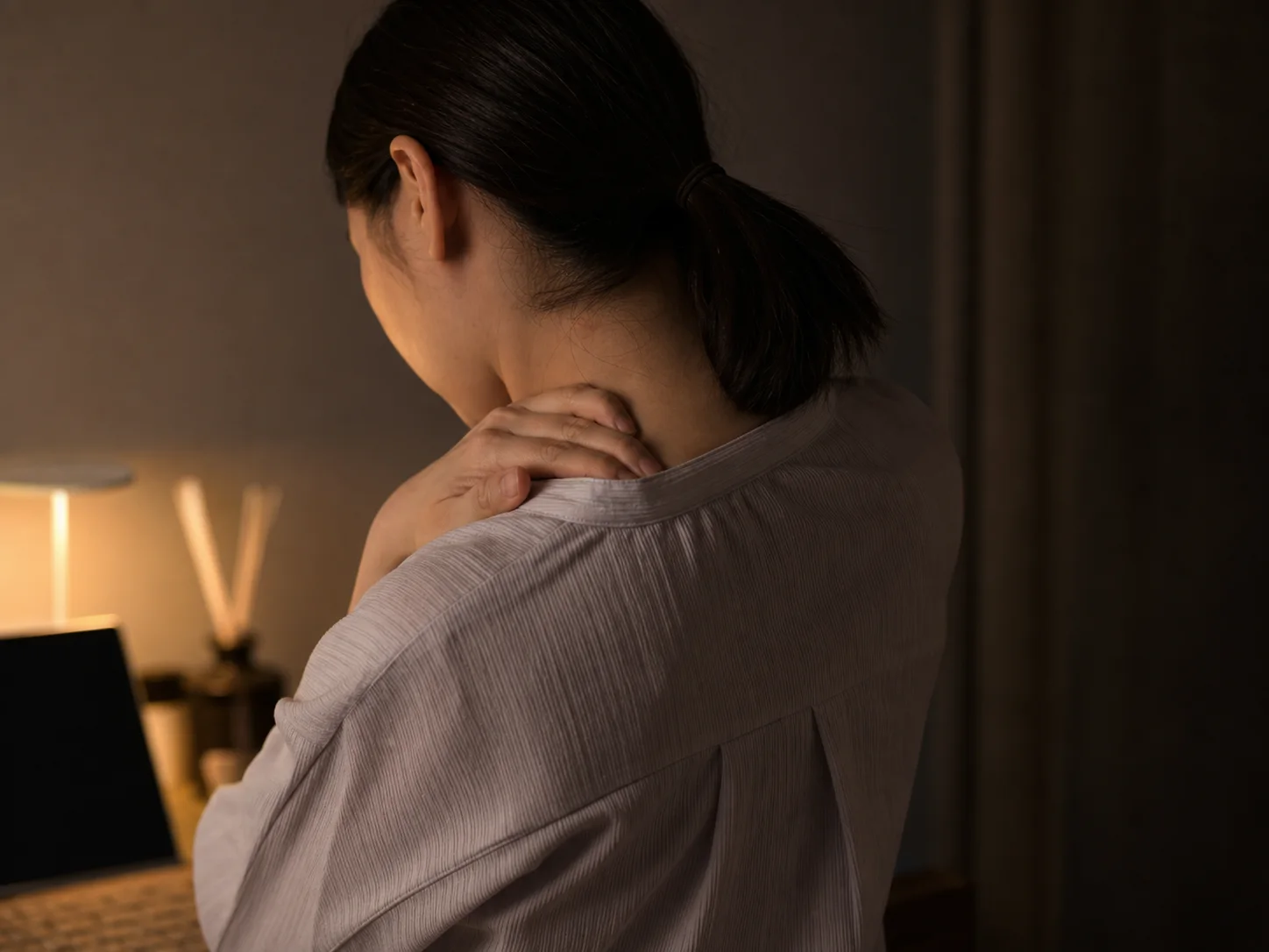 夜に首から肩の状態を自分で確認している人